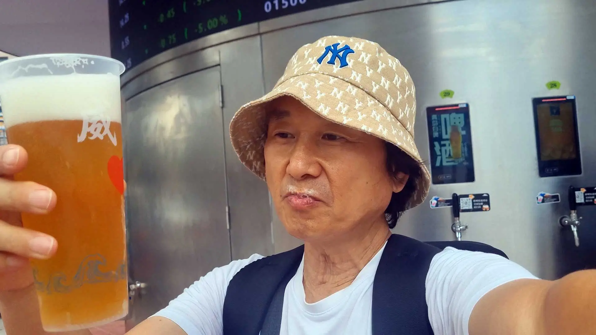 갓 뽑아낸 시원한 칭다오 원액 맥주를 잔에 들고 시음하는 장면